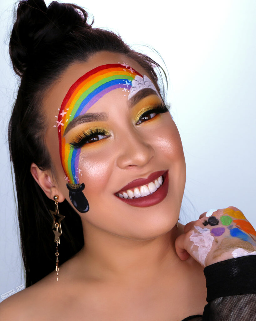 St Patricks Day Makeup with gold eyeshadow and pot of gold with rainbow painted on face