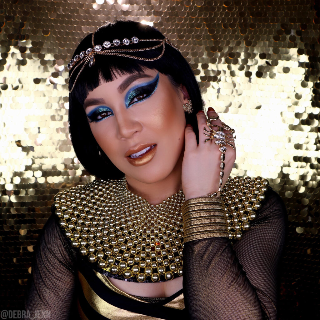 Cleopatra makeup and halloween costume with dramatic blue eyeshadow and lots of gold jewelry