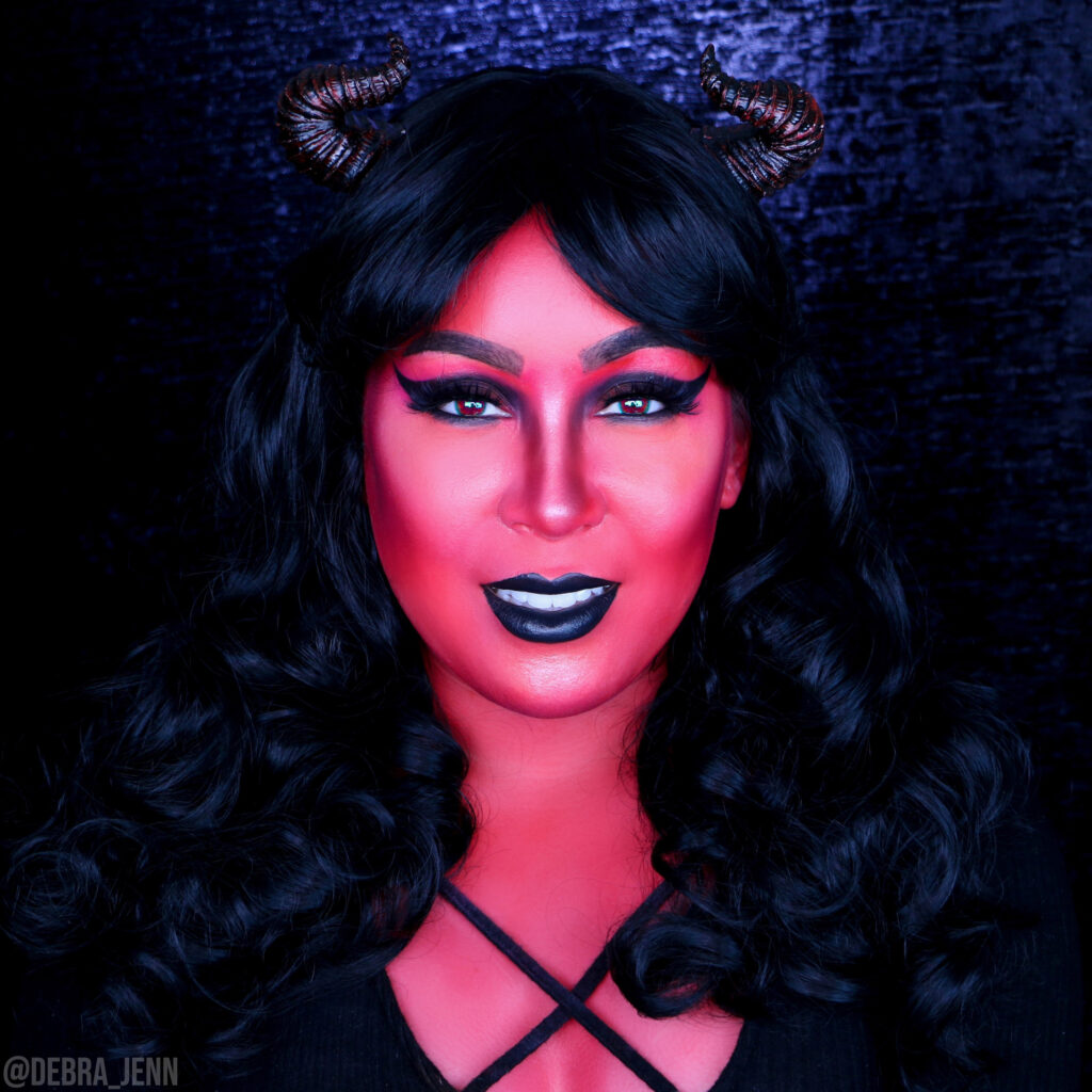 glam devil makeup with 50s style retro hair, winged black eyeshadow and horns