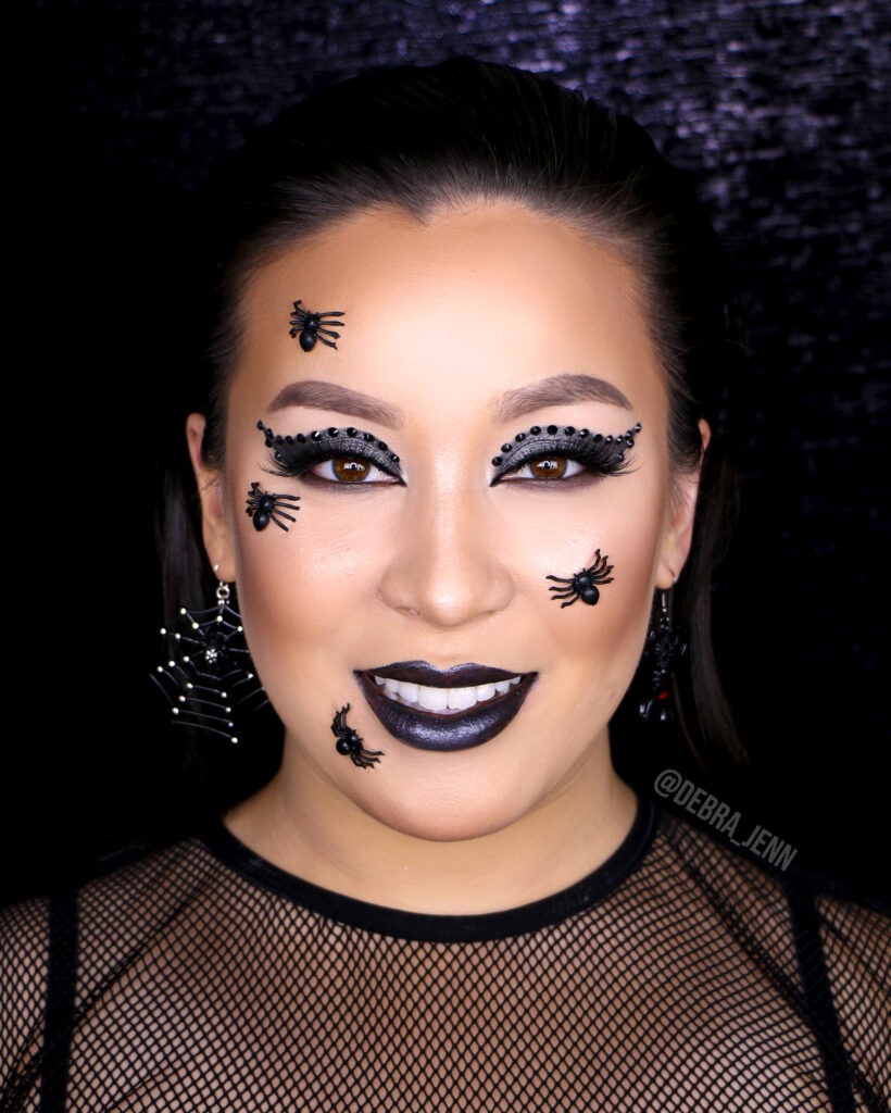 Easy spider makeup with black eyeshadow, black lipstick, and spiders on face