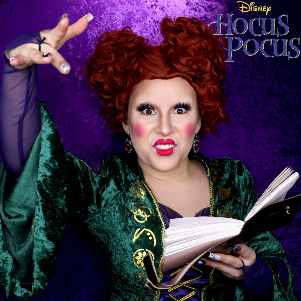 Winifred Sanderson Costume makeup with red curly wig, blushy cheeks, no eyebrows, and weird lips