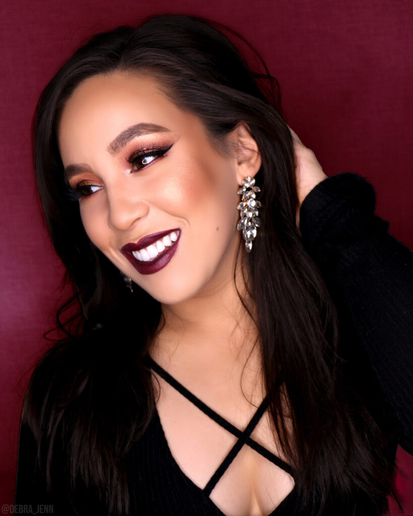 Debra Jenn wearing a burgundy fall makeup look with glitter liner in the crease