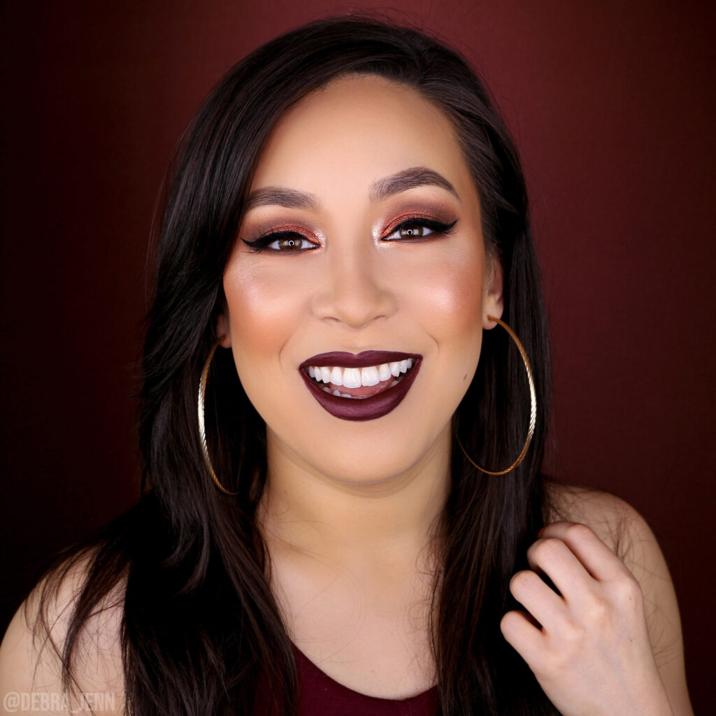 Debra Jenn wearing an easy fall makeup look with brown eyeshadow and dark maroon lipstick