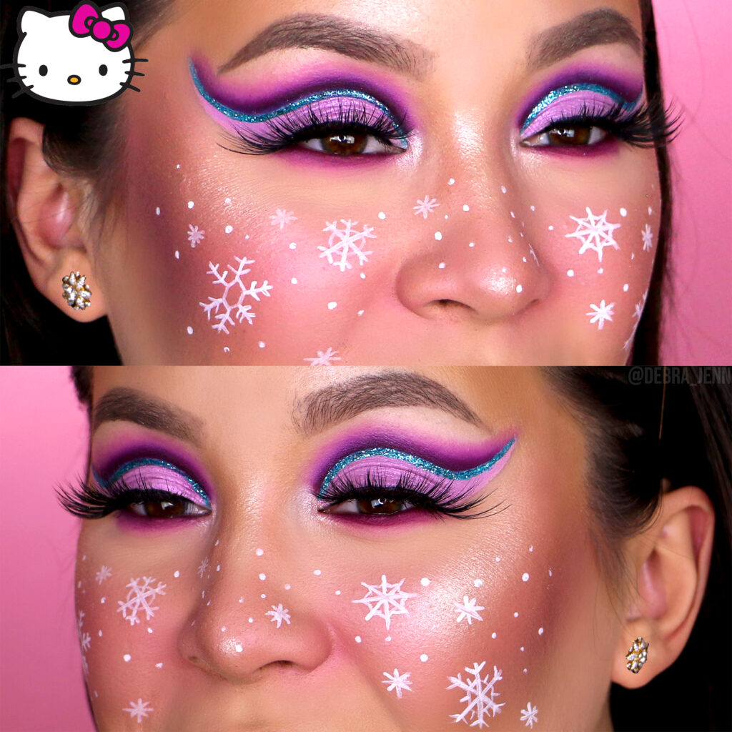Debra Jenn in pink holiday eyeshadow with blue glitter eyeliner and snowflake makeup face paint on the cheeks, another super cute Christmas makeup idea
