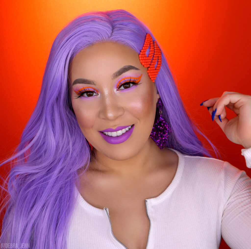 debra jenn in purple eyeshadow with orange eyeliner, purple lipstick, and purple hair